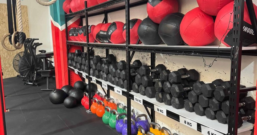 Rack con wall balls y kettlebells en un box de cross training